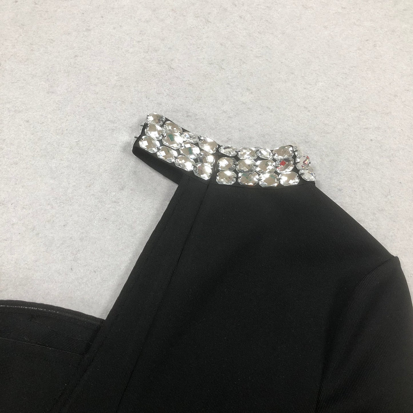 Robe longue noire à une manche et découpe ornée de cristaux