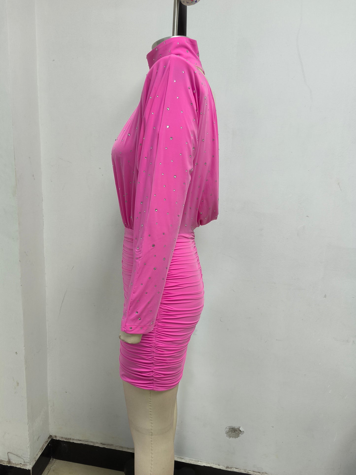 Robe moulante mini rose ornée de cristaux et froncée.