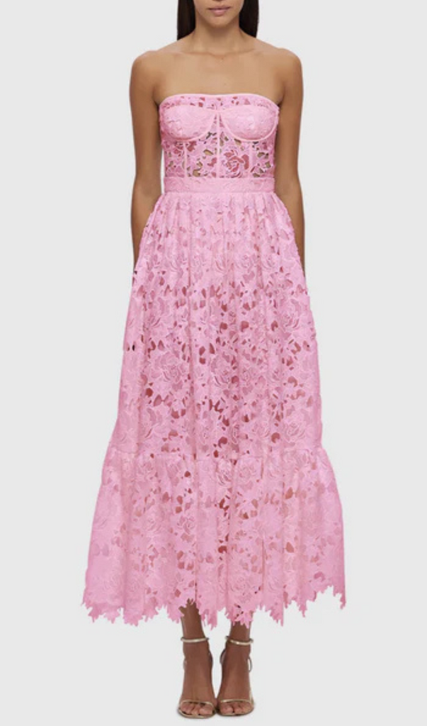 A strapless, candy pink lace midi dress with a gathered skirt and ruffle hem, featuring a floral pattern and a thin adjustable strap.